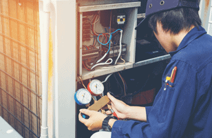 man working with dial gages on an hvac unit 