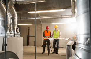 two workers inspecting hvac 