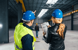 two workers examining a worksite 