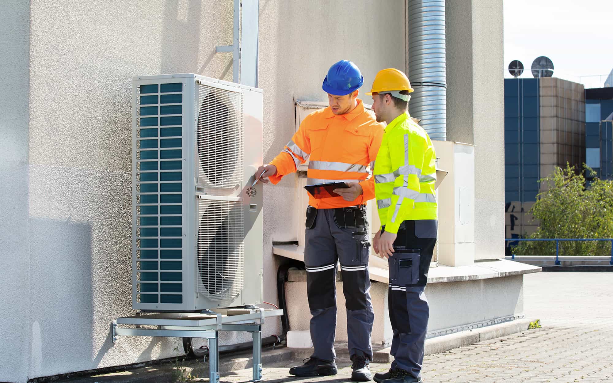 two workers inspecting a heating unit