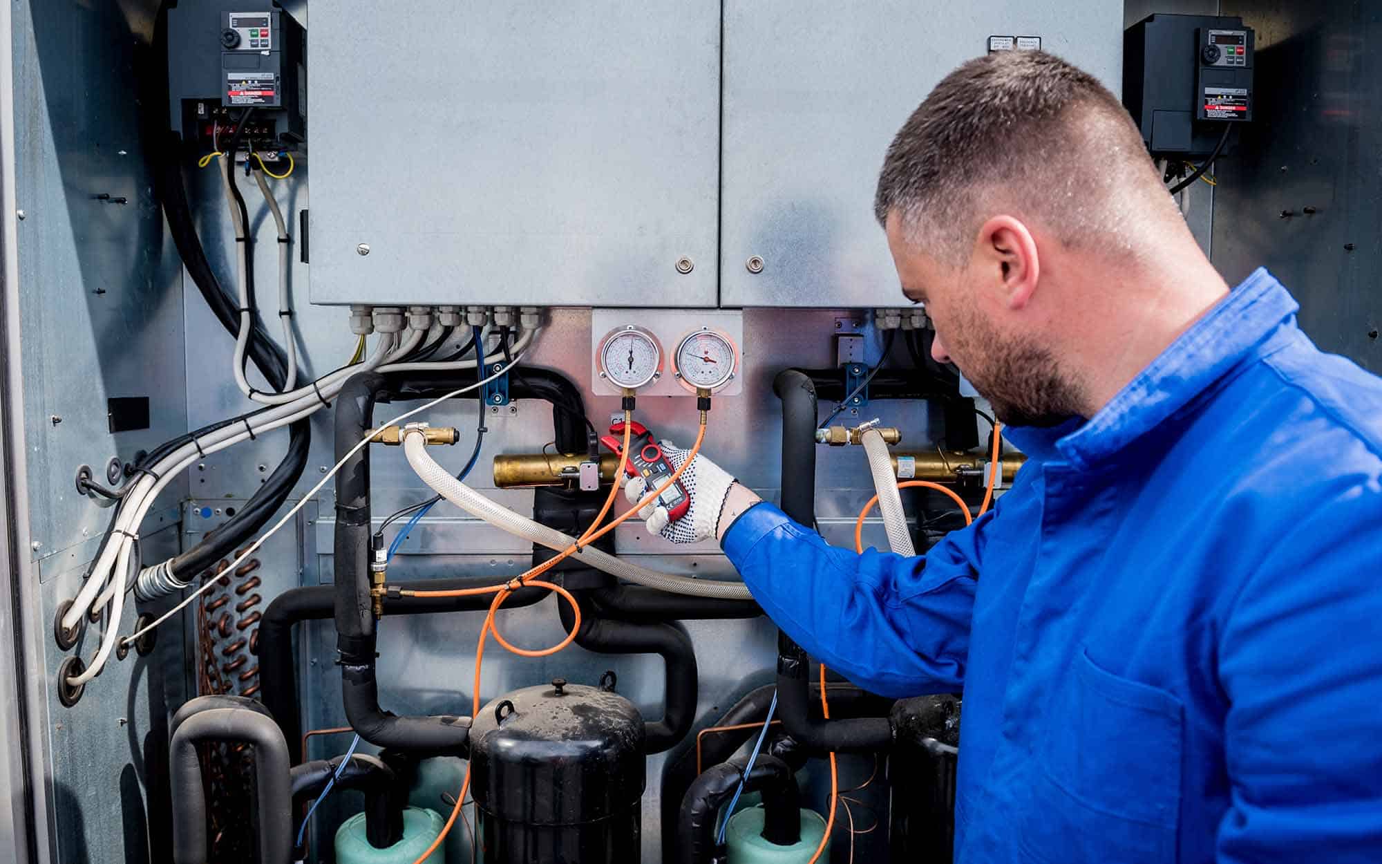 The Technician Checking Power Lines Of The Heat Exchanger With Current Clamps | React Industries