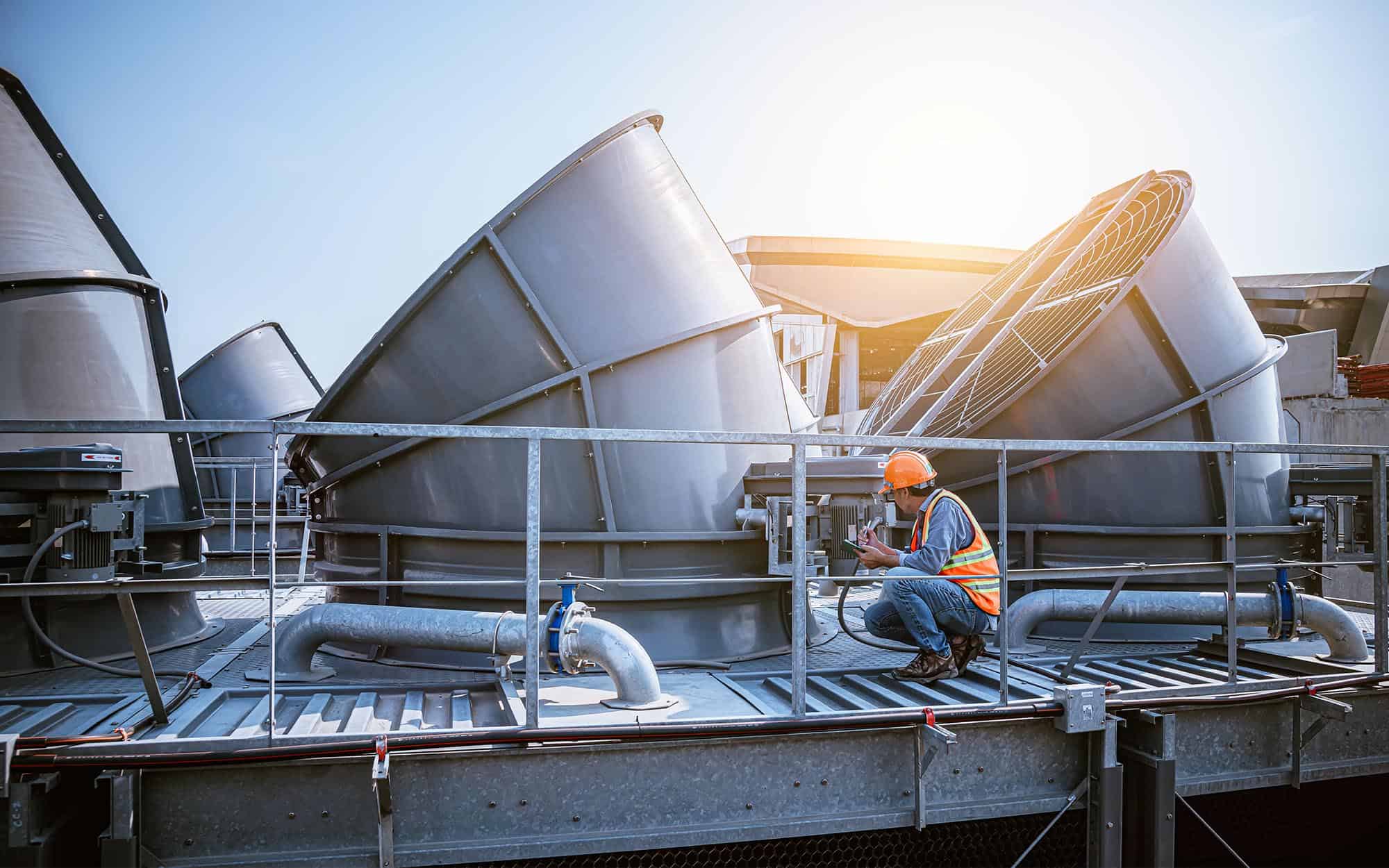 Image Of A Worker Inspecting Hvac Cooling Towers. | React Industries
