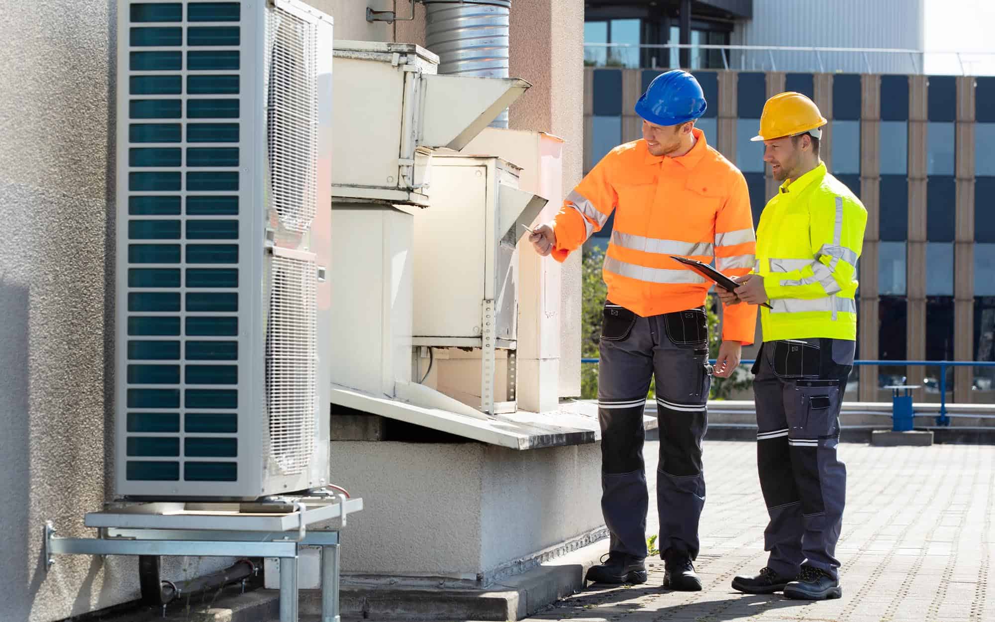 Image Of Two Workers Inspecting An Hvac System For Maintenance. | React Industries