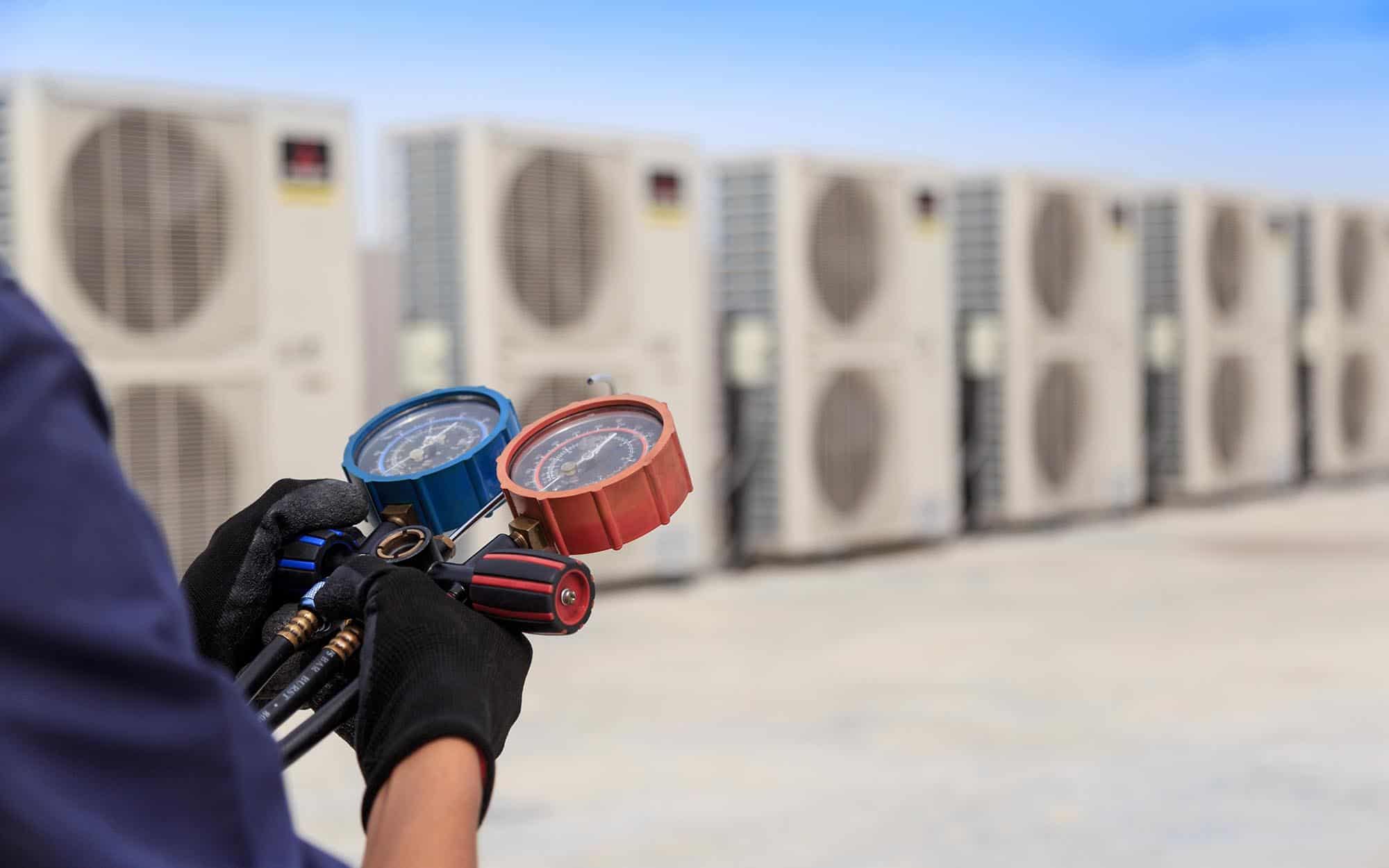 Worker Checking Refrigerant And Filling Industrial Air Conditioner | React Industries